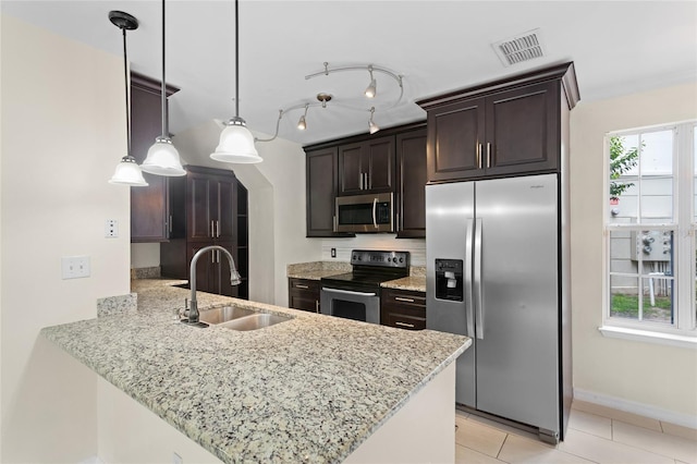 kitchen with a sink, a peninsula, stainless steel appliances, visible vents, and dark brown cabinets