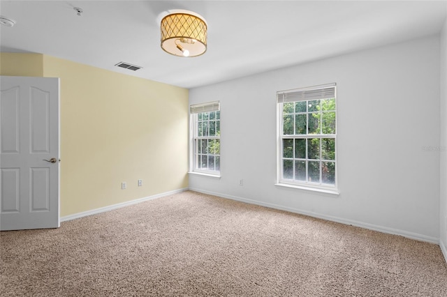 carpeted empty room with baseboards and visible vents