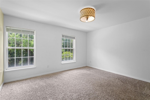 empty room featuring carpet and baseboards