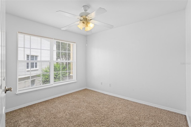 carpeted empty room featuring baseboards and ceiling fan