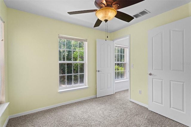 unfurnished bedroom featuring visible vents, baseboards, ceiling fan, and carpet floors