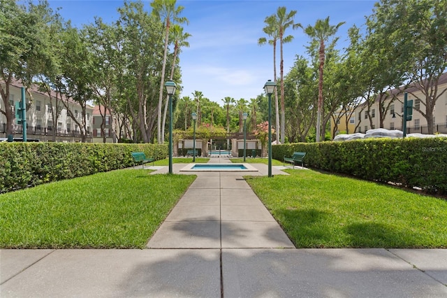 view of property's community featuring a yard, a patio area, and a swimming pool