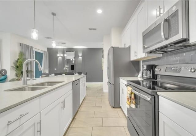 4983 Windermere Ave, Kissimmee, FL 34746 - kitchen featuring appliances with stainless steel finishes, a sink, white cabinets, light countertops, and recessed lighting