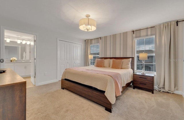 4983 Windermere Ave, Kissimmee, FL 34746 - bedroom featuring light carpet, baseboards, a closet, and ensuite bath