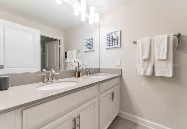 4983 Windermere Ave, Kissimmee, FL 34746 - full bath with baseboards, double vanity, and tile patterned flooring