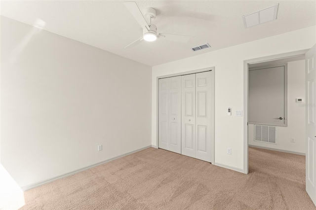 unfurnished bedroom featuring light carpet, a closet, baseboards, and a ceiling fan