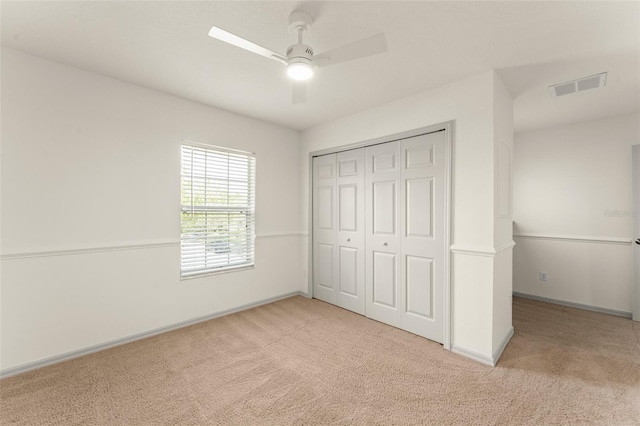 unfurnished bedroom with carpet, baseboards, a closet, and a ceiling fan