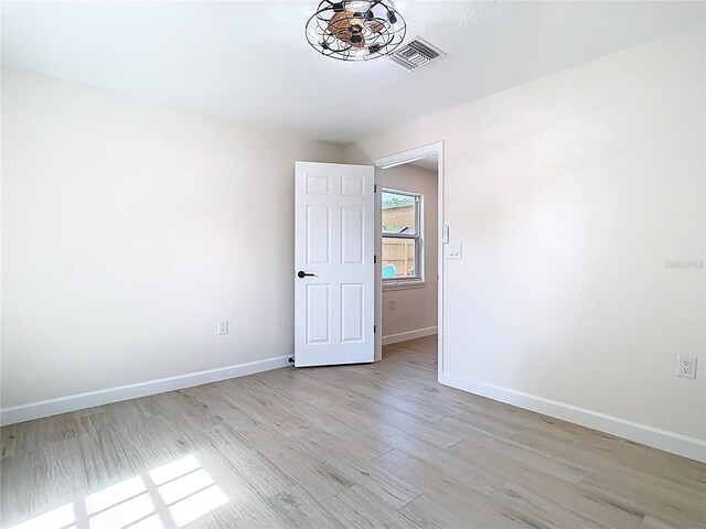 empty room featuring baseboards and light wood finished floors