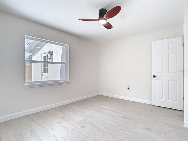 spare room with a ceiling fan, baseboards, and wood finished floors
