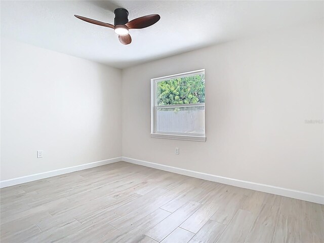 unfurnished room with a ceiling fan, light wood-style flooring, and baseboards