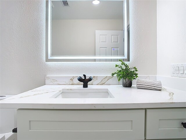 bathroom featuring vanity and a textured wall