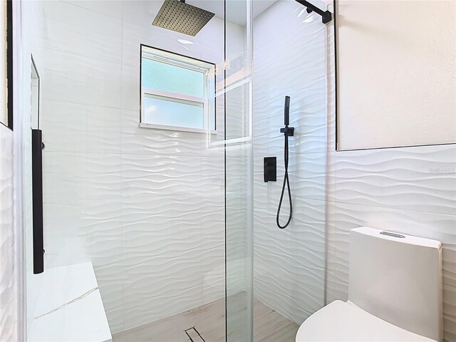 bathroom featuring a walk in shower and toilet