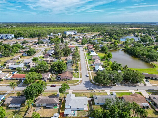 aerial view of property and surrounding area with a nearby body of water and nearby suburban area