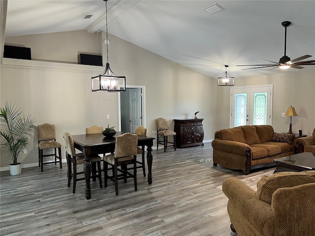 dining area with visible vents, vaulted ceiling with beams, ceiling fan with notable chandelier, and light wood-style floors