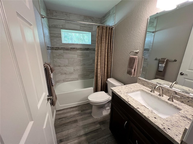 full bath featuring vanity, a textured wall, wood finished floors, toilet, and shower / bathtub combination with curtain