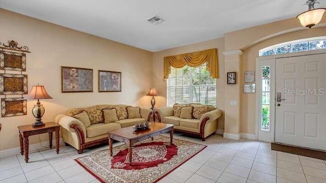 living area with light tile patterned floors, baseboards, plenty of natural light, and visible vents