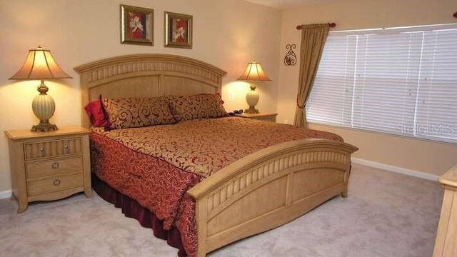 bedroom featuring baseboards and light colored carpet