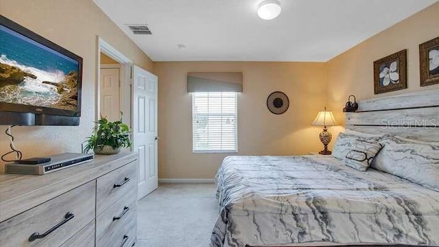 bedroom with visible vents, baseboards, and light carpet