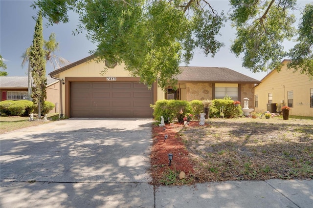 7418 Riverbank Dr, New Port Richey, FL 34655 - view of front of home with driveway, a garage, and central AC