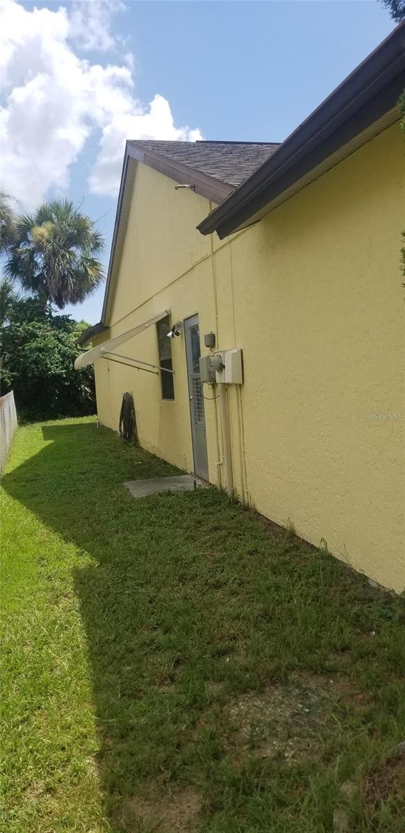 7418 Riverbank Dr, New Port Richey, FL 34655 - view of home's exterior with stucco siding and a lawn