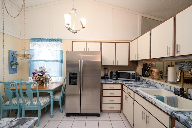 7418 Riverbank Dr, New Port Richey, FL 34655 - kitchen with stainless steel appliances, a sink, a chandelier, light tile patterned floors, and decorative light fixtures