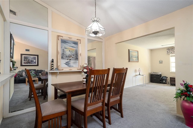 7418 Riverbank Dr, New Port Richey, FL 34655 - carpeted dining area with vaulted ceiling and a chandelier