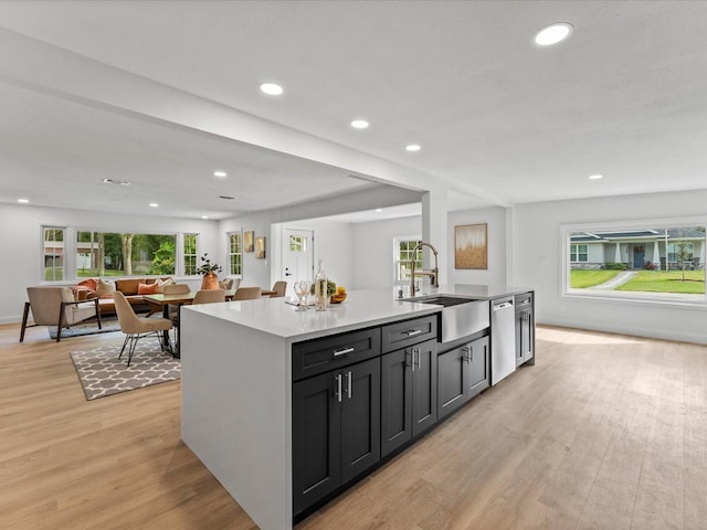2205 Pine Island Dr, New Smyrna Beach, FL 32168 - kitchen featuring a sink, stainless steel dishwasher, light wood finished floors, open floor plan, and light countertops