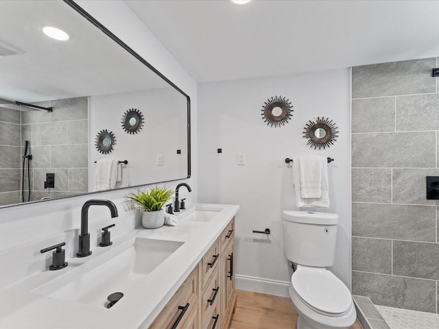 2205 Pine Island Dr, New Smyrna Beach, FL 32168 - full bath featuring toilet, wood finished floors, a tile shower, double vanity, and baseboards