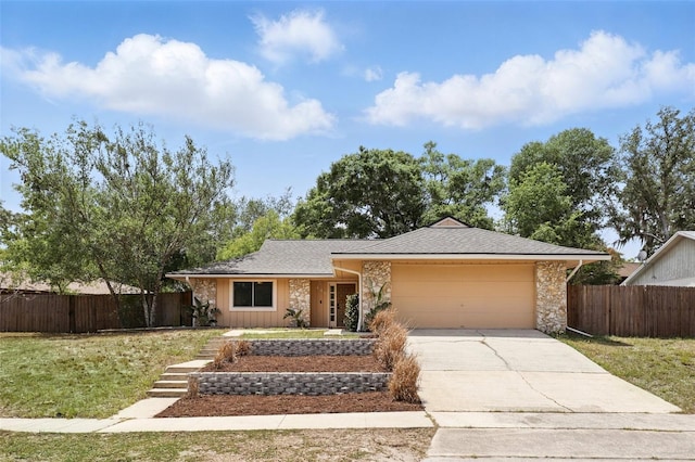 ranch-style home featuring an attached garage, concrete driveway, fence, and a front yard