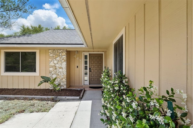 view of exterior entry with a shingled roof