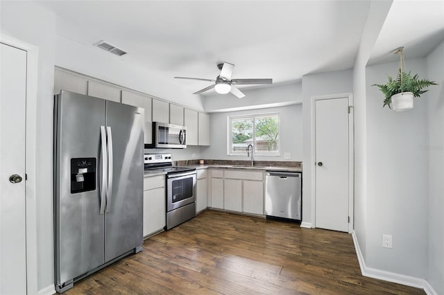 kitchen with a sink, visible vents, dark wood-style flooring, a ceiling fan, and appliances with stainless steel finishes