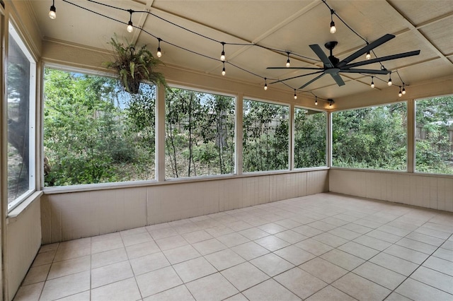 unfurnished sunroom featuring wood walls, track lighting, and tile patterned floors