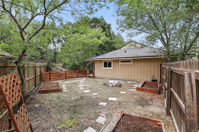 view of yard with a fenced backyard and a garden