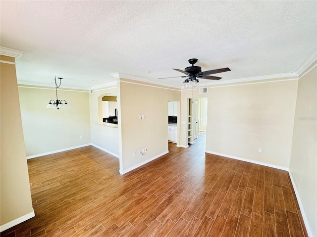 unfurnished room with baseboards, ceiling fan with notable chandelier, visible vents, and wood finished floors