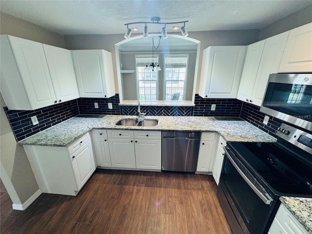 kitchen with a sink, stainless steel appliances, white cabinetry, and dark wood-type flooring