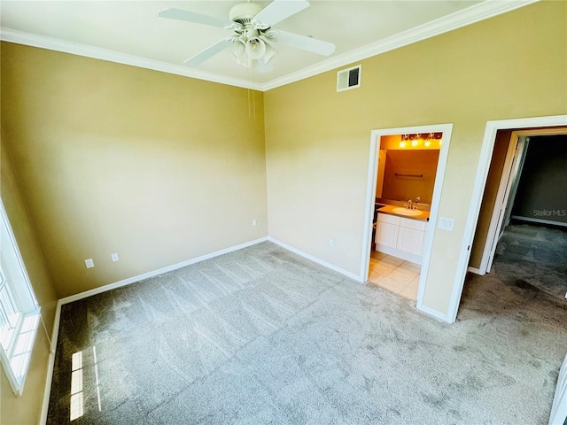 unfurnished bedroom with carpet flooring, a sink, baseboards, ornamental molding, and connected bathroom