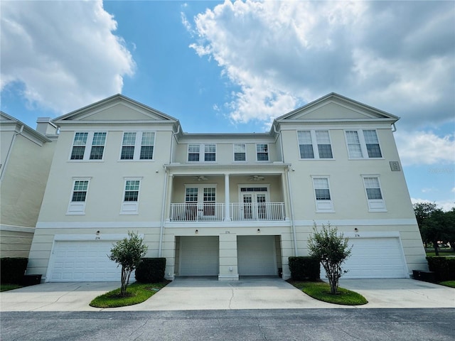 view of front of house featuring a balcony, driveway, stucco siding, and a garage
