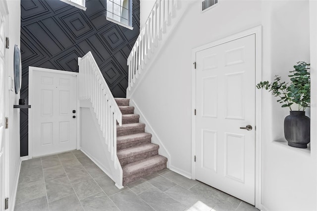 stairs with baseboards and visible vents