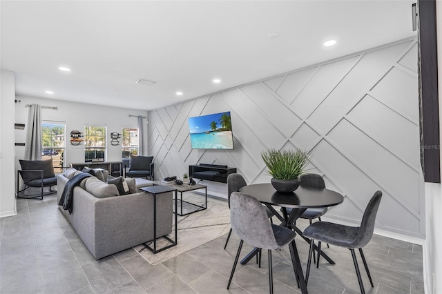 living room with recessed lighting and a decorative wall