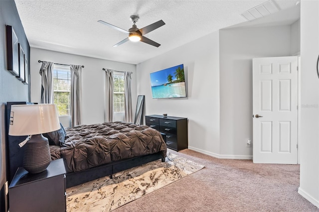 bedroom featuring baseboards, carpet flooring, a textured ceiling, and visible vents