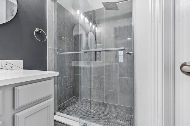 bathroom with a shower stall and vanity