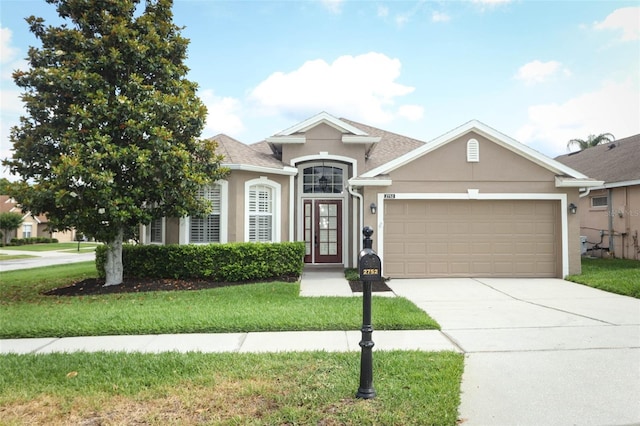 2752 Bellewater Pl, Oviedo, FL 32765 - view of front facade featuring stucco siding, a garage, driveway, and a front lawn