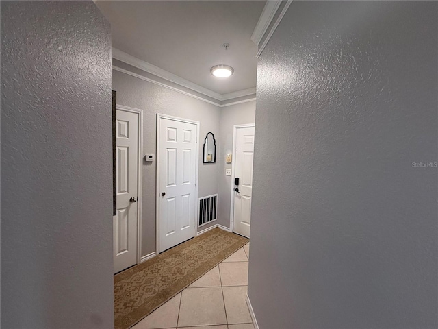 4333 Bayside Village Dr Unit 310, Tampa, FL 33615 - corridor with a textured wall, light tile patterned floors, and crown molding