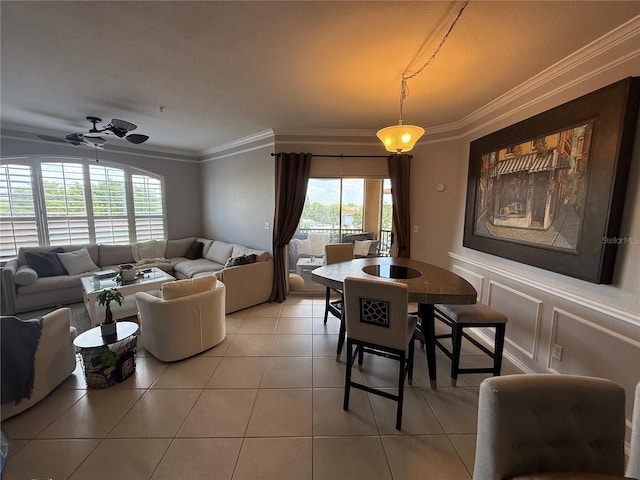 4333 Bayside Village Dr Unit 310, Tampa, FL 33615 - dining room with light tile patterned floors, ornamental molding, a wainscoted wall, a decorative wall, and a ceiling fan