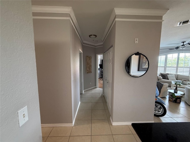 4333 Bayside Village Dr Unit 310, Tampa, FL 33615 - corridor featuring ornamental molding, light tile patterned floors, a textured wall, and baseboards