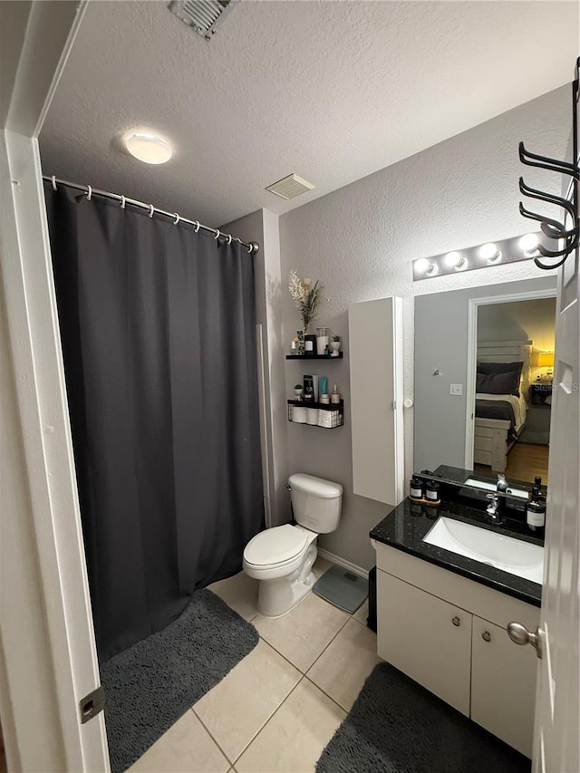 4333 Bayside Village Dr Unit 310, Tampa, FL 33615 - full bathroom featuring vanity, toilet, tile patterned flooring, a shower with curtain, and a textured wall