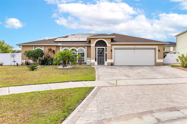 5113 Sage Way, Kissimmee, FL 34758 - mediterranean / spanish house with decorative driveway, stucco siding, a garage, and roof mounted solar panels