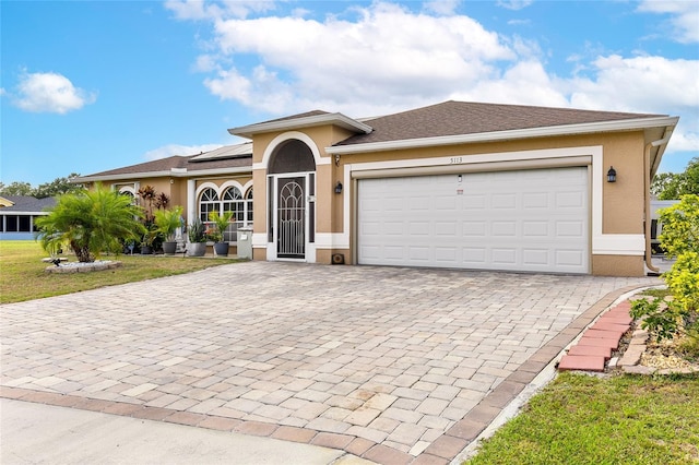 5113 Sage Way, Kissimmee, FL 34758 - view of front of property featuring stucco siding, decorative driveway, roof mounted solar panels, and a garage