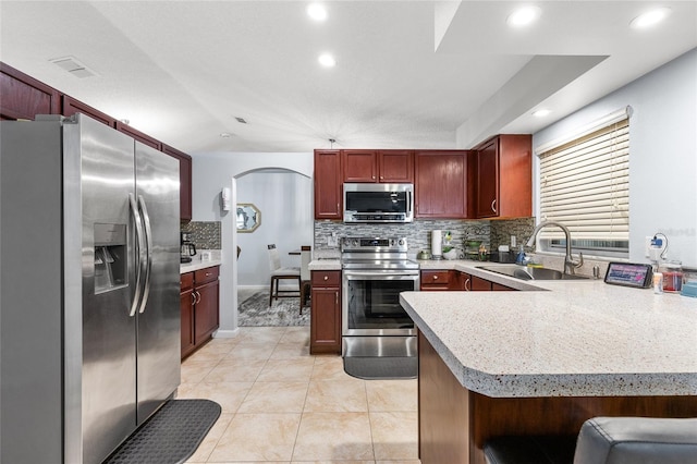 5113 Sage Way, Kissimmee, FL 34758 - kitchen with appliances with stainless steel finishes, a sink, reddish brown cabinets, backsplash, and recessed lighting