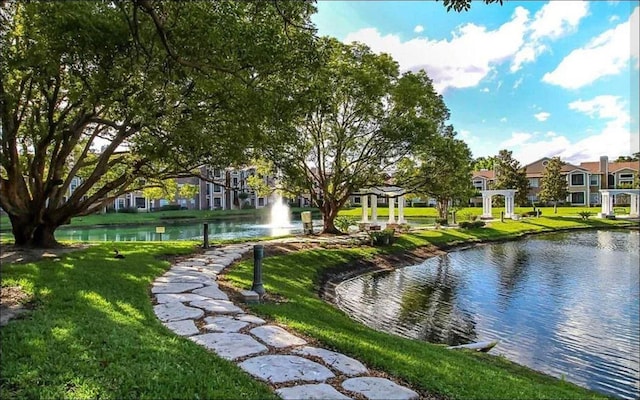 surrounding community featuring a residential view, a water view, and a lawn